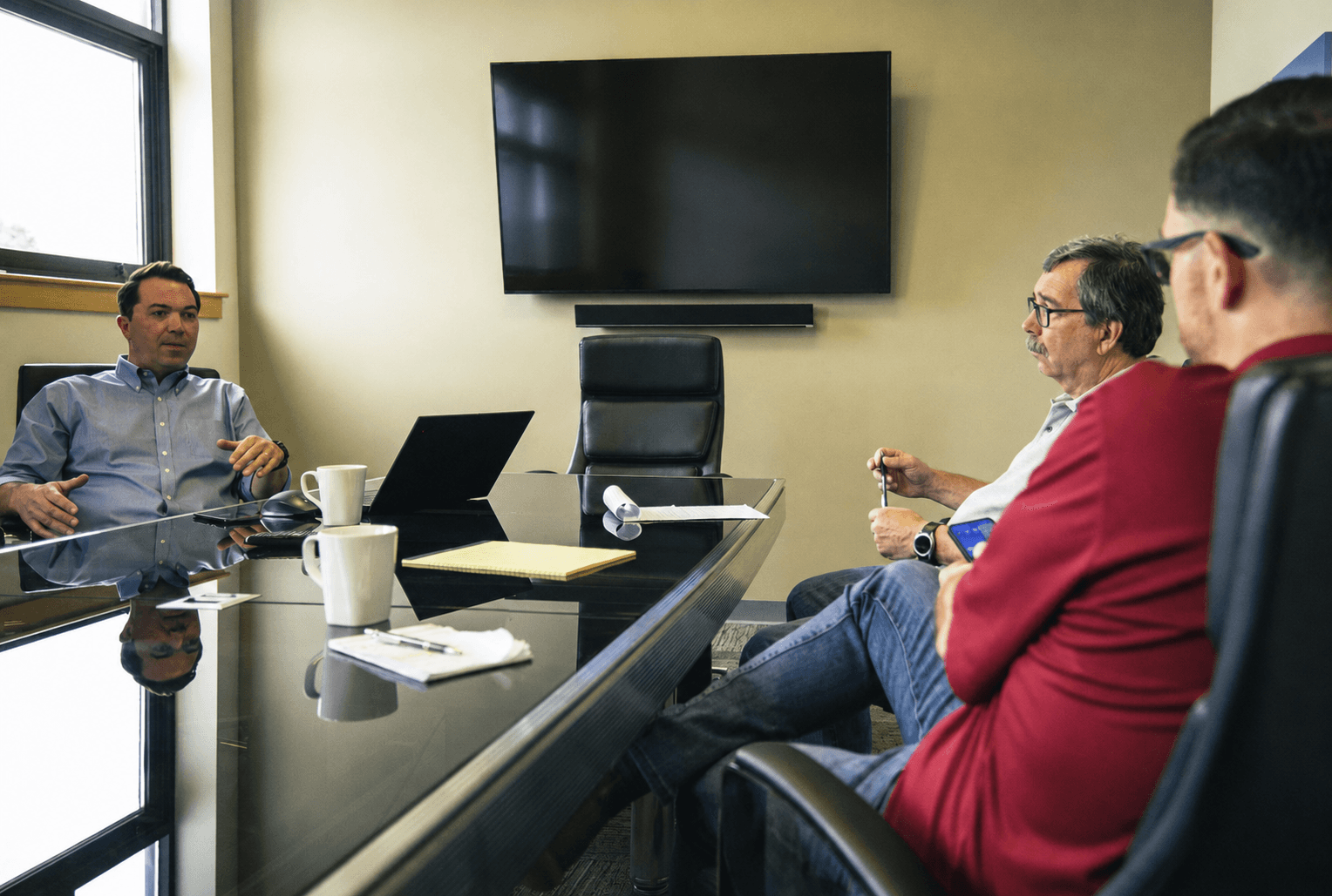 Rugged team members reviewing a build with a customer around the conference table at the New Hampshire factory