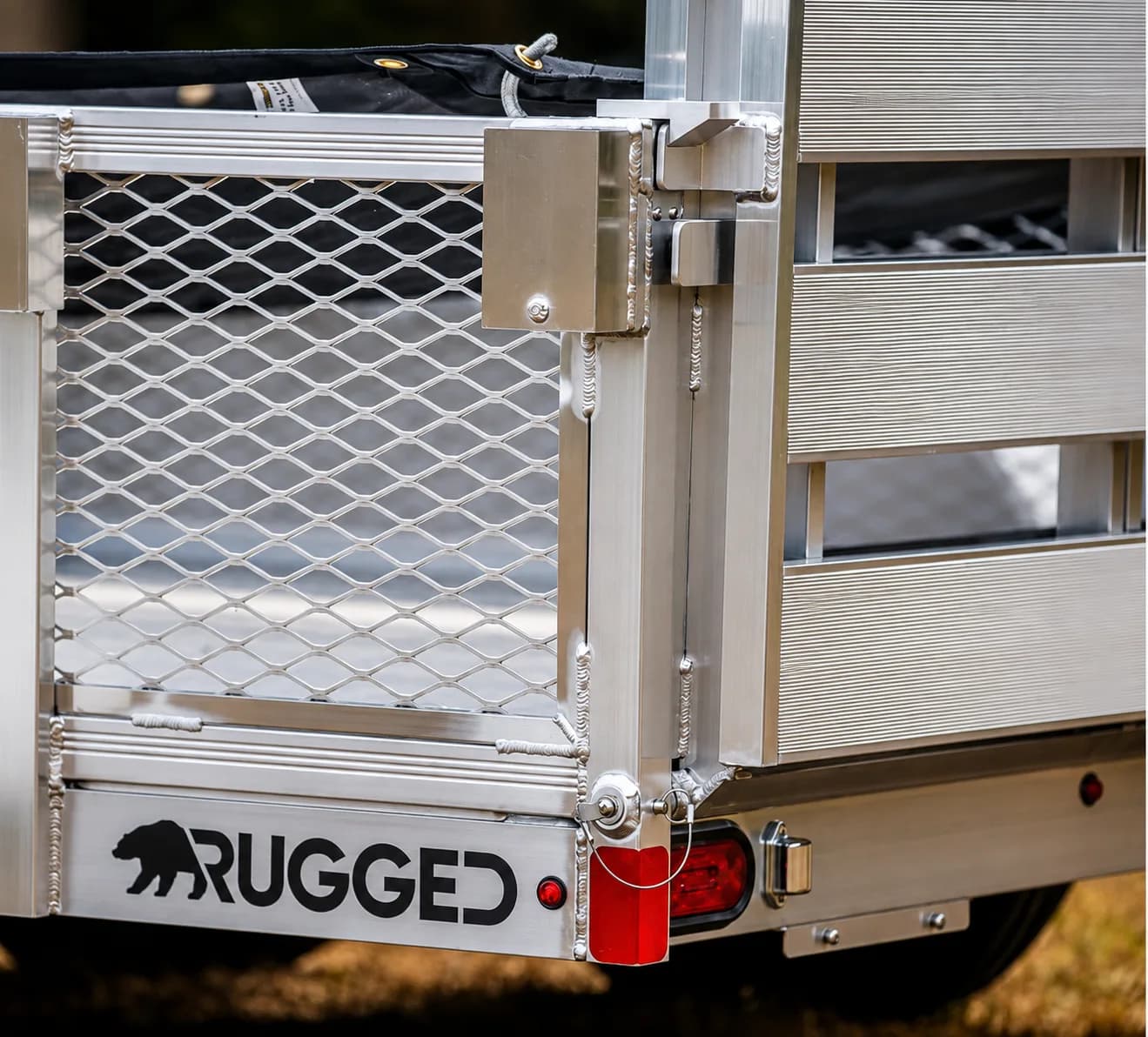 Close-up of the AutoLatch mechanism on the rear corner of a Rugged utility trailer tailgate