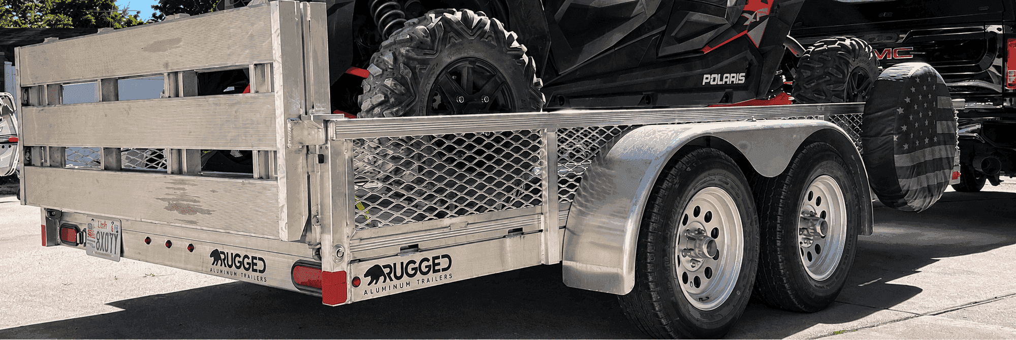 Rugged 6.5 × 12 tandem-axle utility trailer with rail side kit hauling a Polaris side-by-side