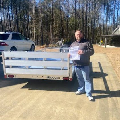 Michael G standing next to a trailer in a driveway