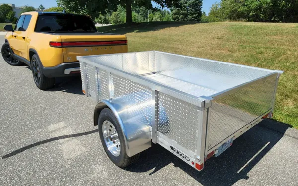 yellow trailer pulling an aluminum trailer