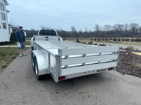 Anthony H standing next to a trailer with tread plate side rails attached to a truck