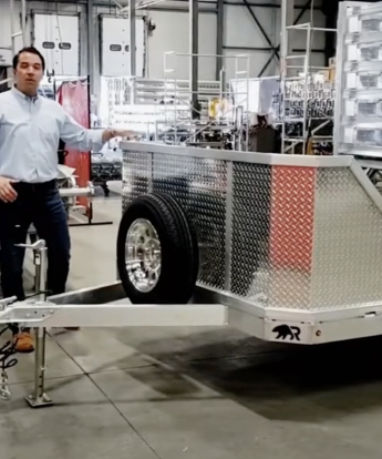 6.5' x 12' Motorcycle Trailer in a warehouse with a man in the background