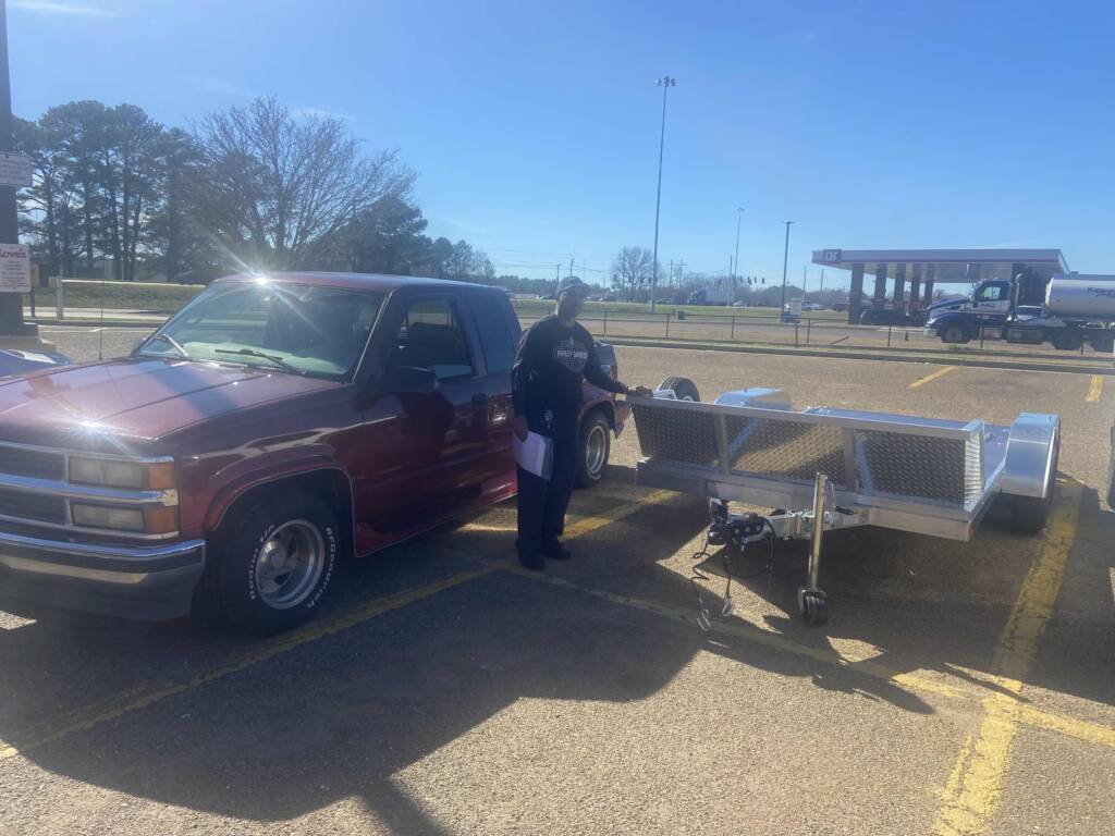 Anderson G standing next to trailer with tread plate side rails in a parking lot